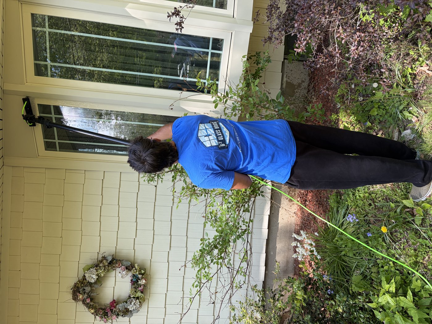 G2 Glass Bros technician cleaning a bay window with a water-fed pole